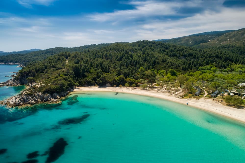 The long, golden sandy beach of Armenistis, with the famous campsite nestled in the trees behind it.