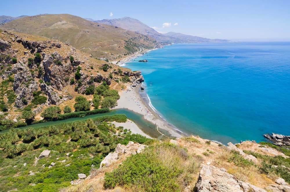 The magical Preveli Beach where a river flows through a palm forest to meet the sea.