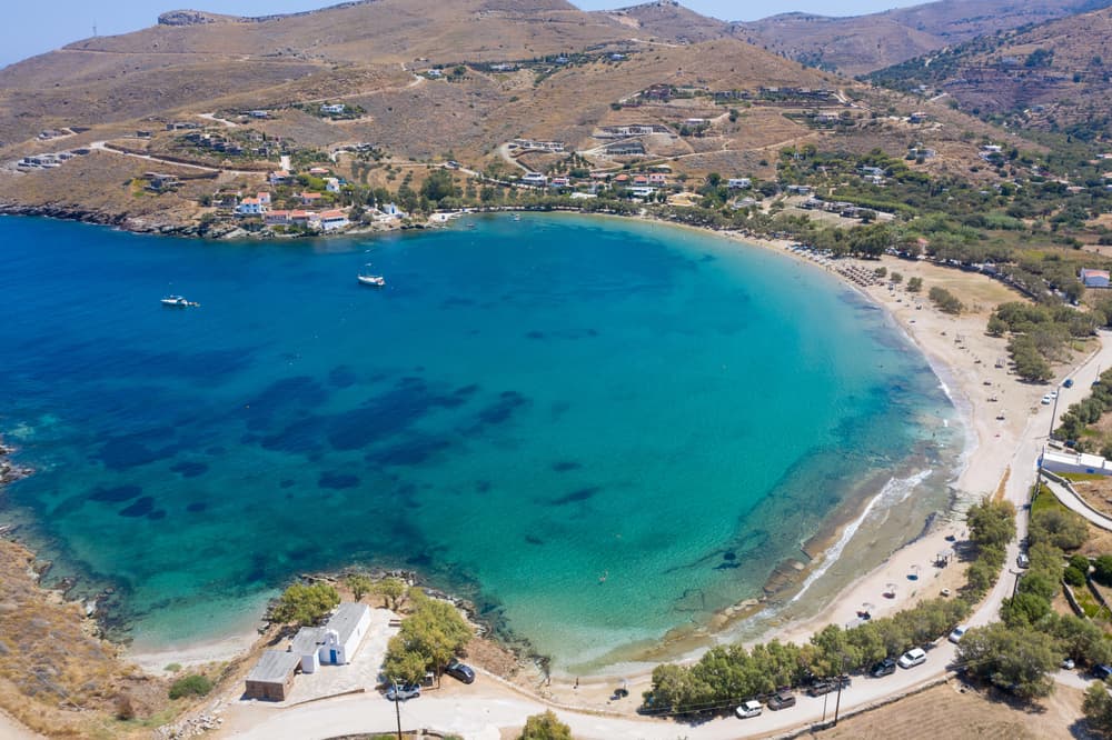 The wide, sheltered bay of Otzias Beach in Kea, with tamarisk trees lining the golden sand.