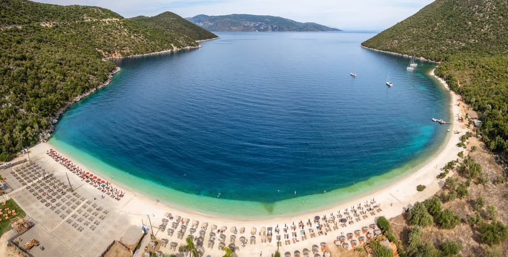 The lush green hills surrounding the stunningly clear, emerald waters of Antisamos Beach, near Sami.