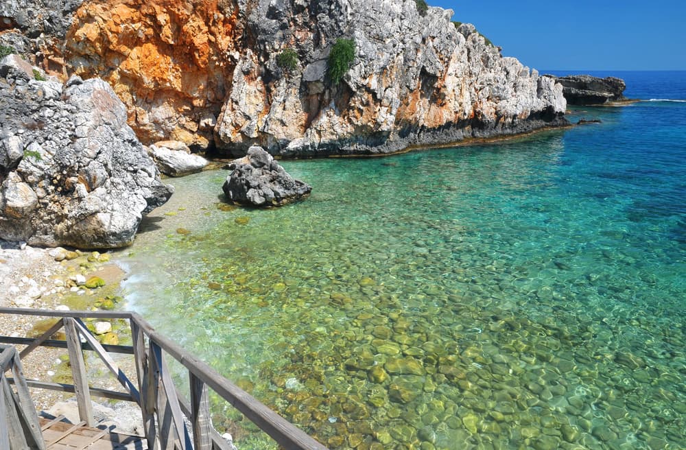 The long, organized stretch of golden sand and blue sea at the resort of Skala Beach, Kefalonia.