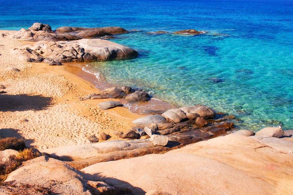 The picturesque small fishing port and cedar trees of Agia Anna Beach, Naxos.