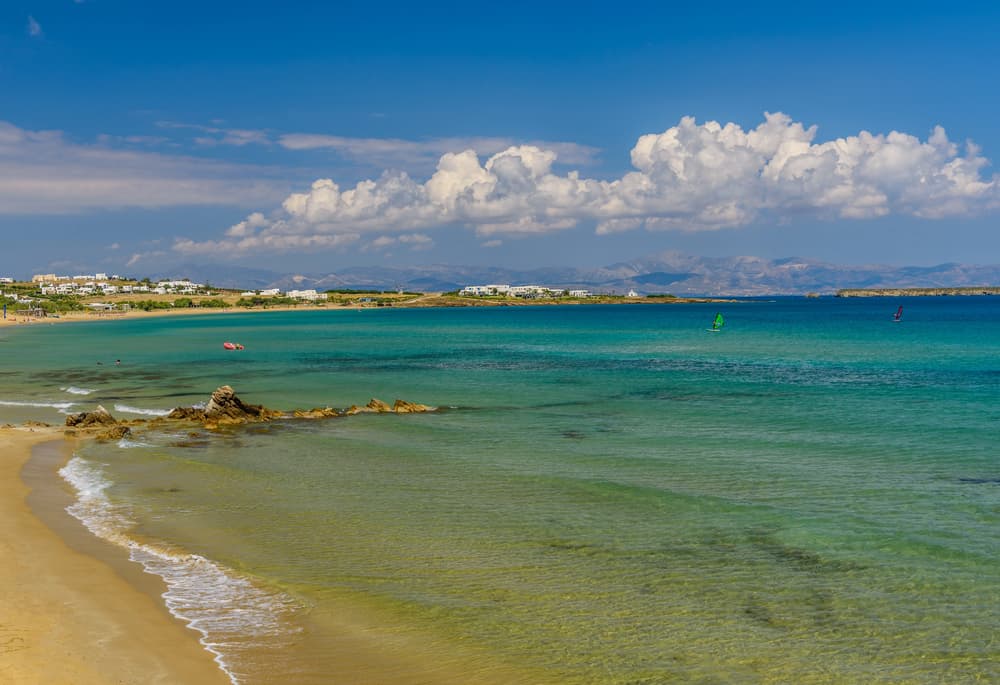 Windsurfers gliding across the water at the long, sandy Golden Beach (Chrysi Akti) in Paros.