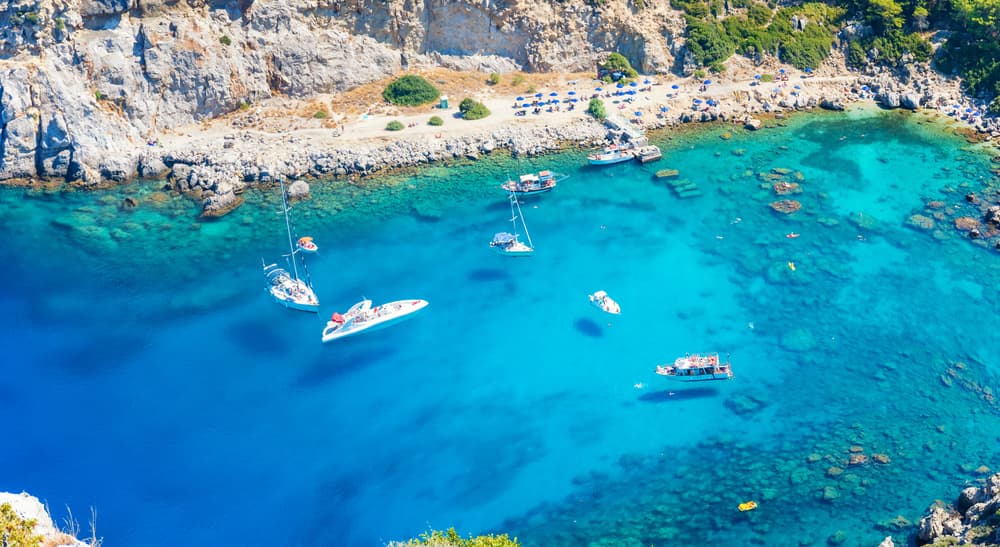The stunning emerald green waters and rocky landscape of Anthony Quinn Bay, Rhodes.