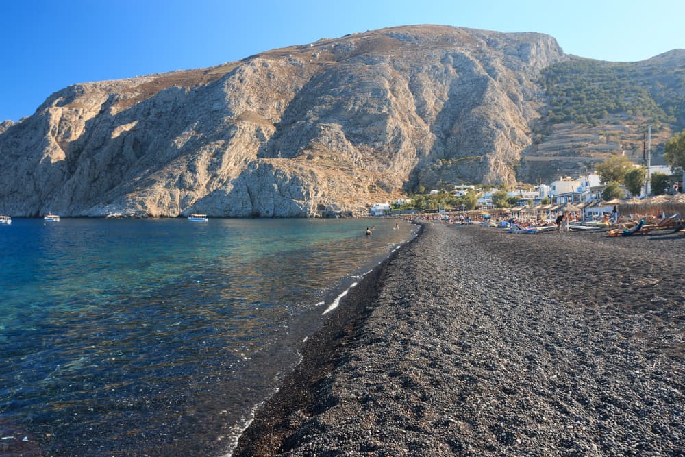 The organized, family-friendly promenade of Kamari Beach with Mesa Vouno in the background.