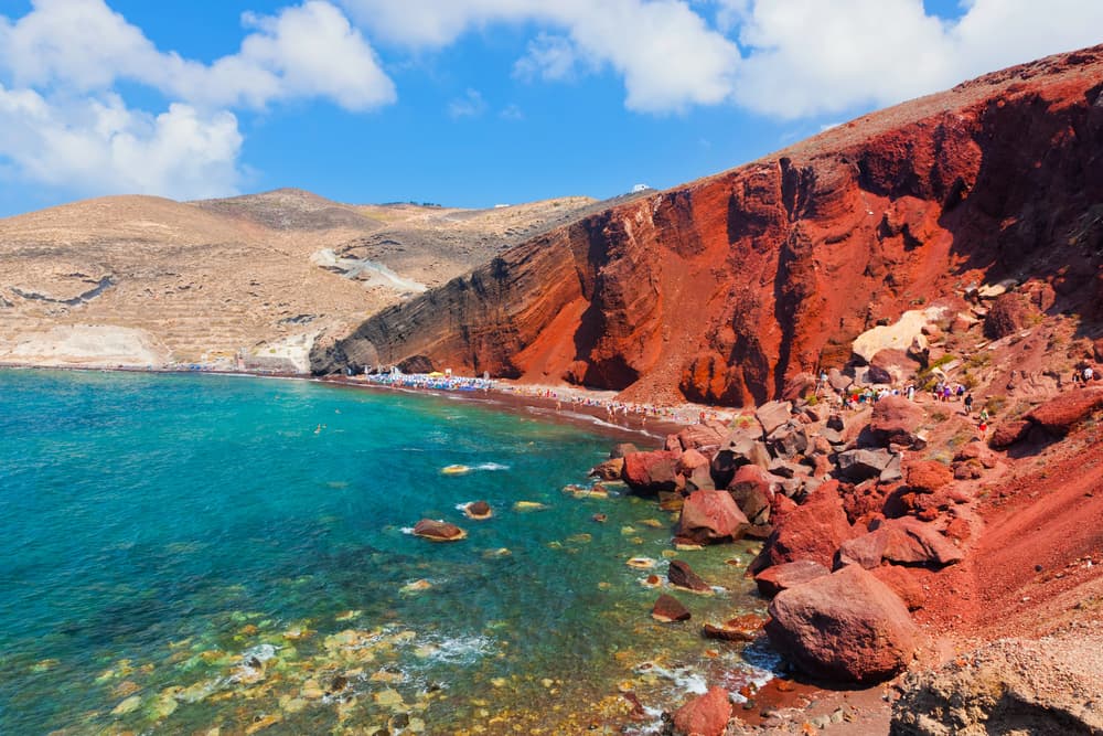 The stunning red volcanic cliffs and dark waters of Red Beach, Santorini.