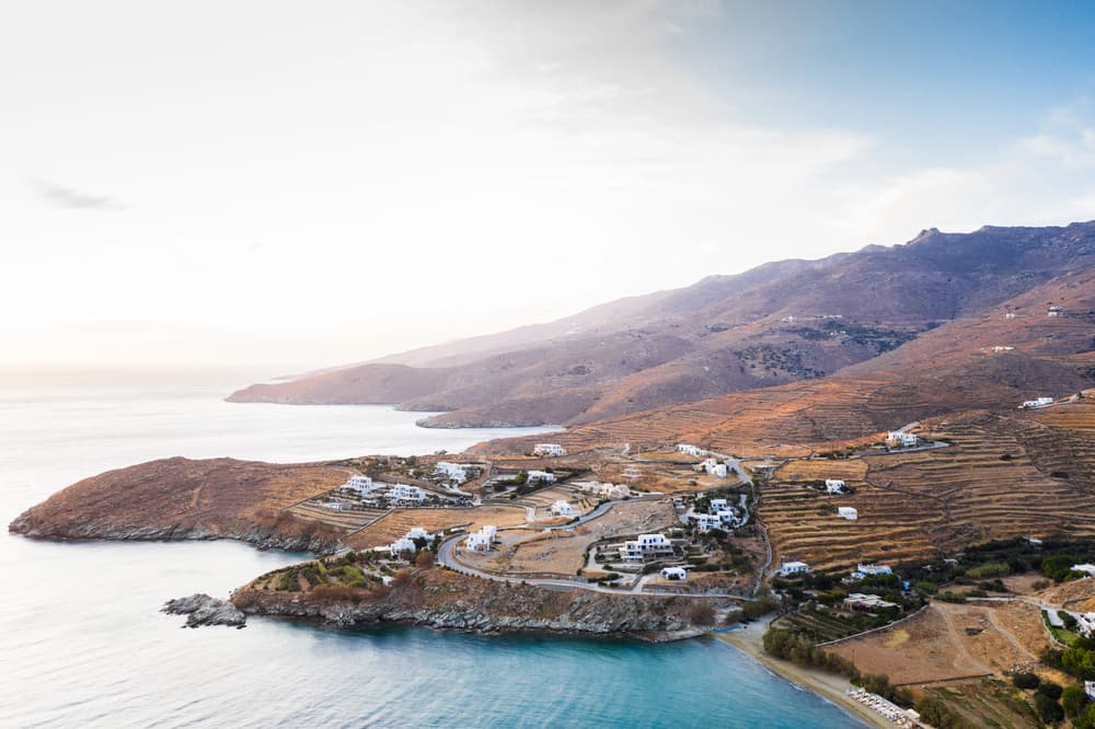 The tranquil, sandy beach of Agios Romanos in Tinos, with tamarisk trees providing natural shade.