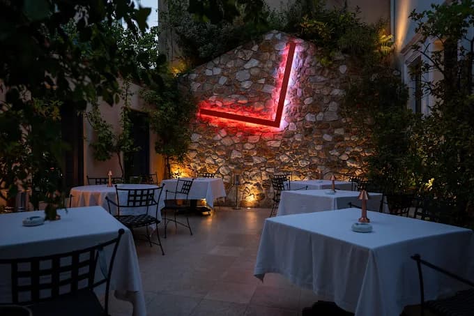The elegant and historic stone courtyard of the two-Michelin-starred Spondi restaurant in Athens.