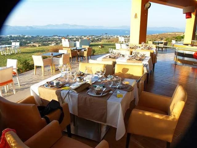 The stunning panoramic view of Kos Town and the sea from the terrace of Lofaki Restaurant at sunset.