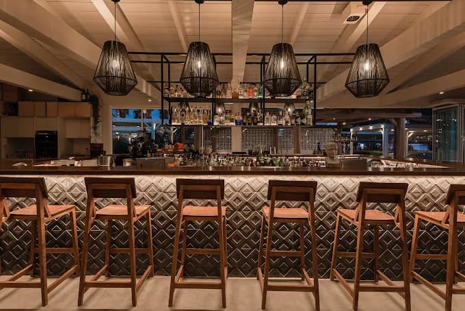 The relaxed, bohemian vibe of Yazoo Summer Bliss beach bar on Agios Georgios beach at dusk.